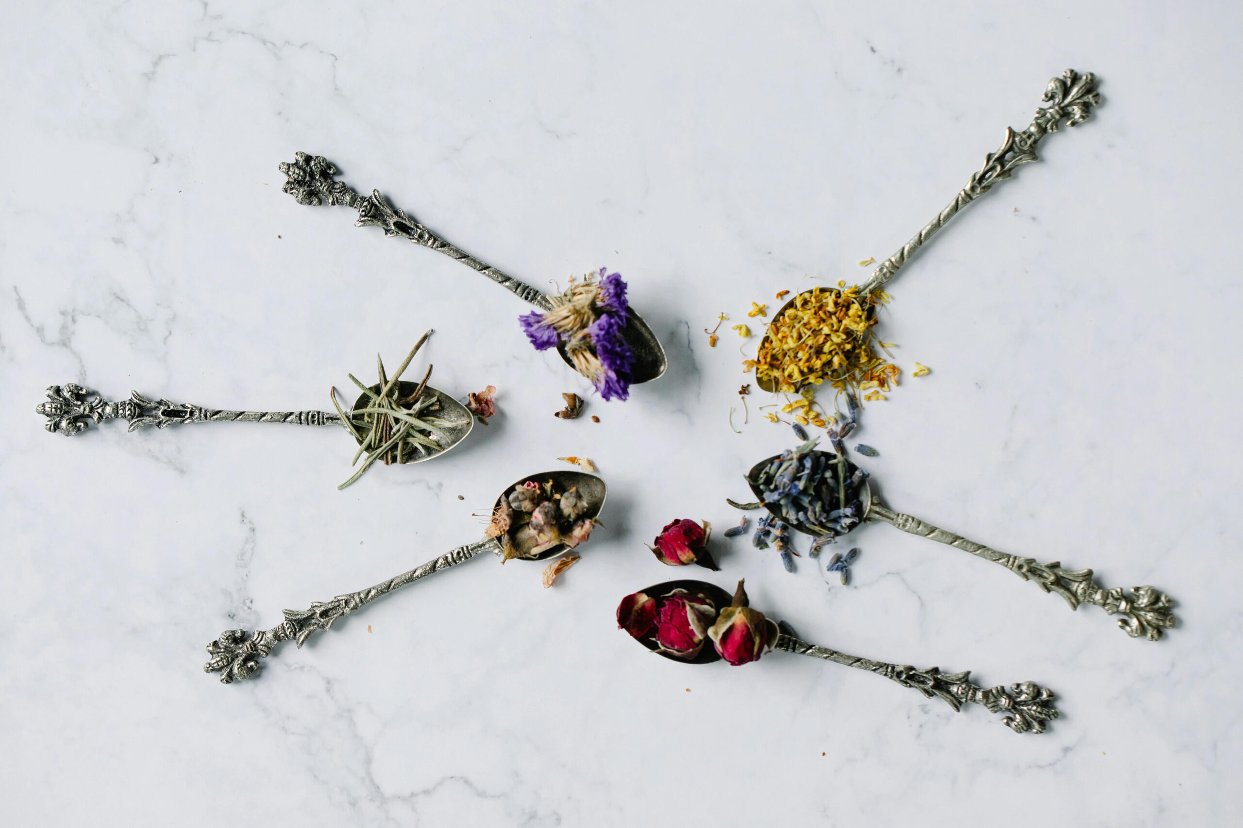 a set of six spoons with dried flowers
