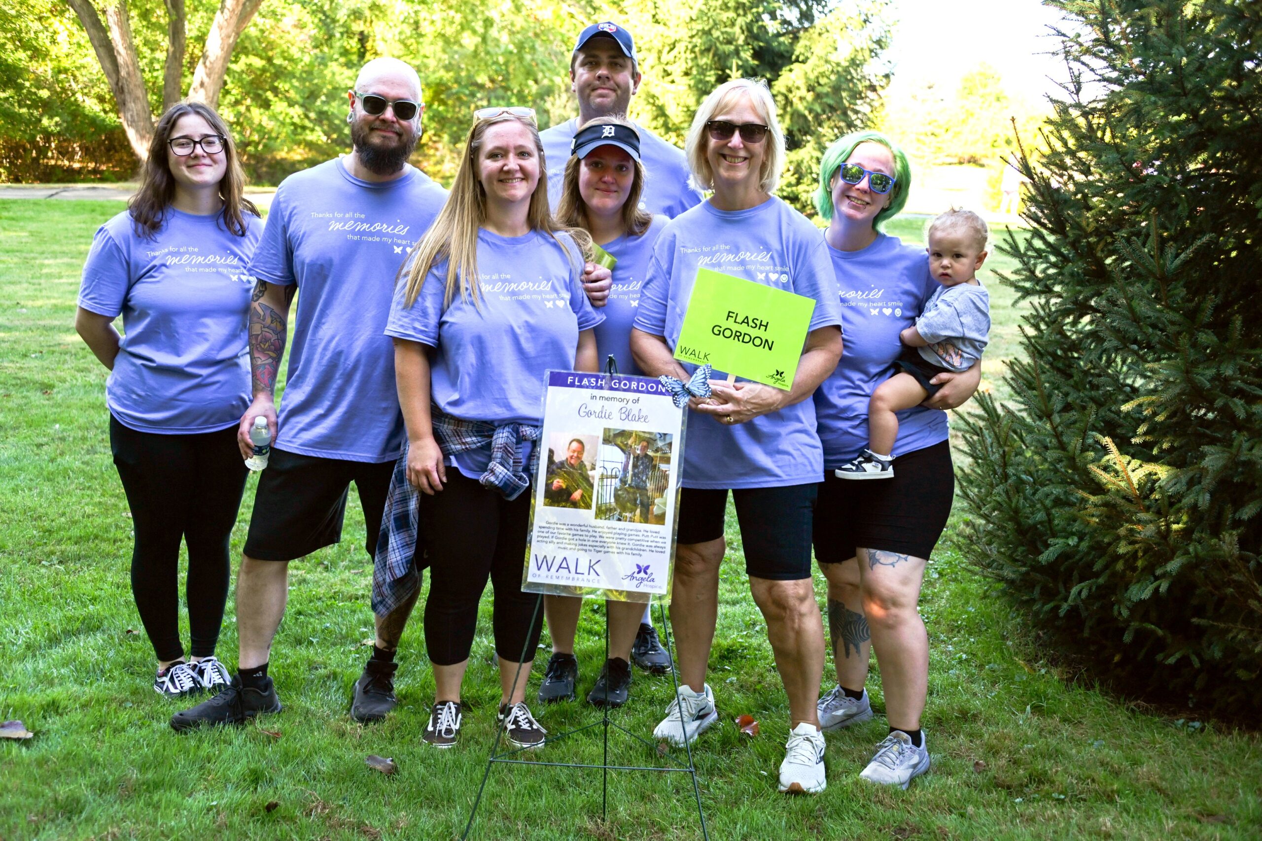 family in matching T-shirts holds a sign that reads "Flash Gordon"