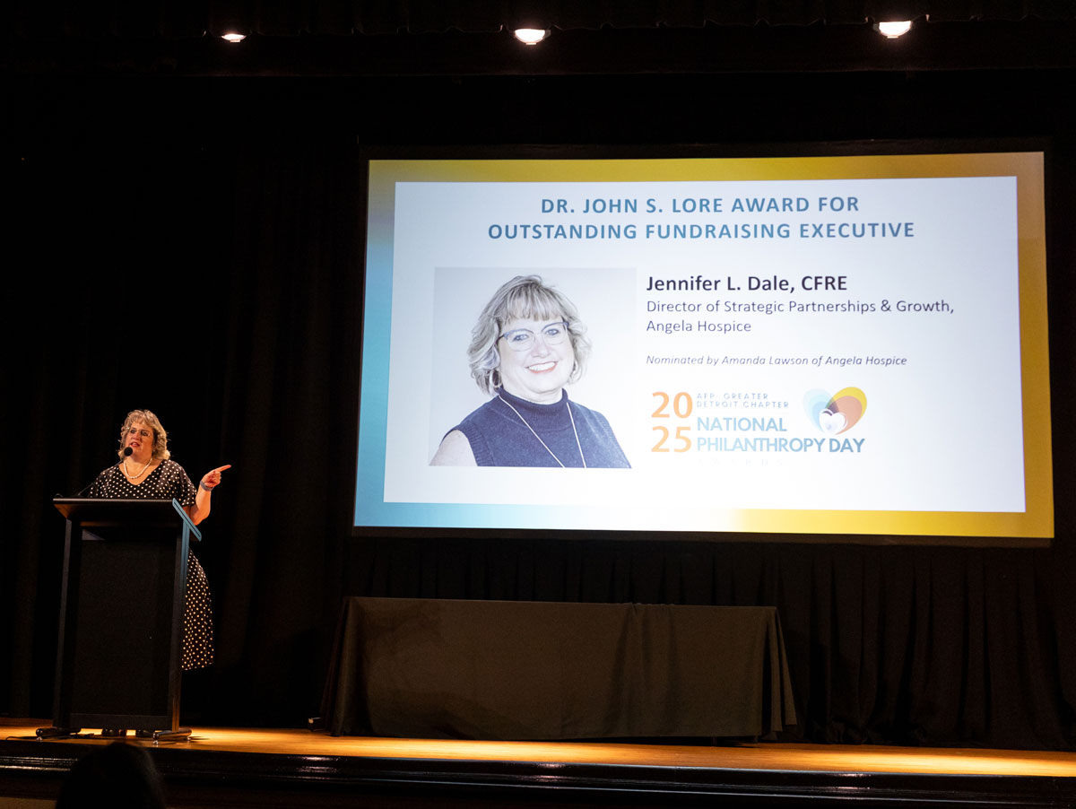 Jennifer Dale gives a speech on stage at an awards banquet