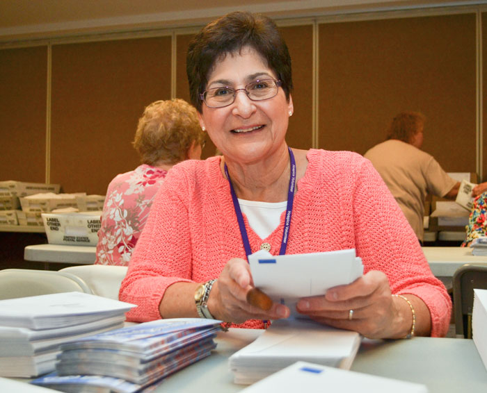 a volunteer stacks envelopes
