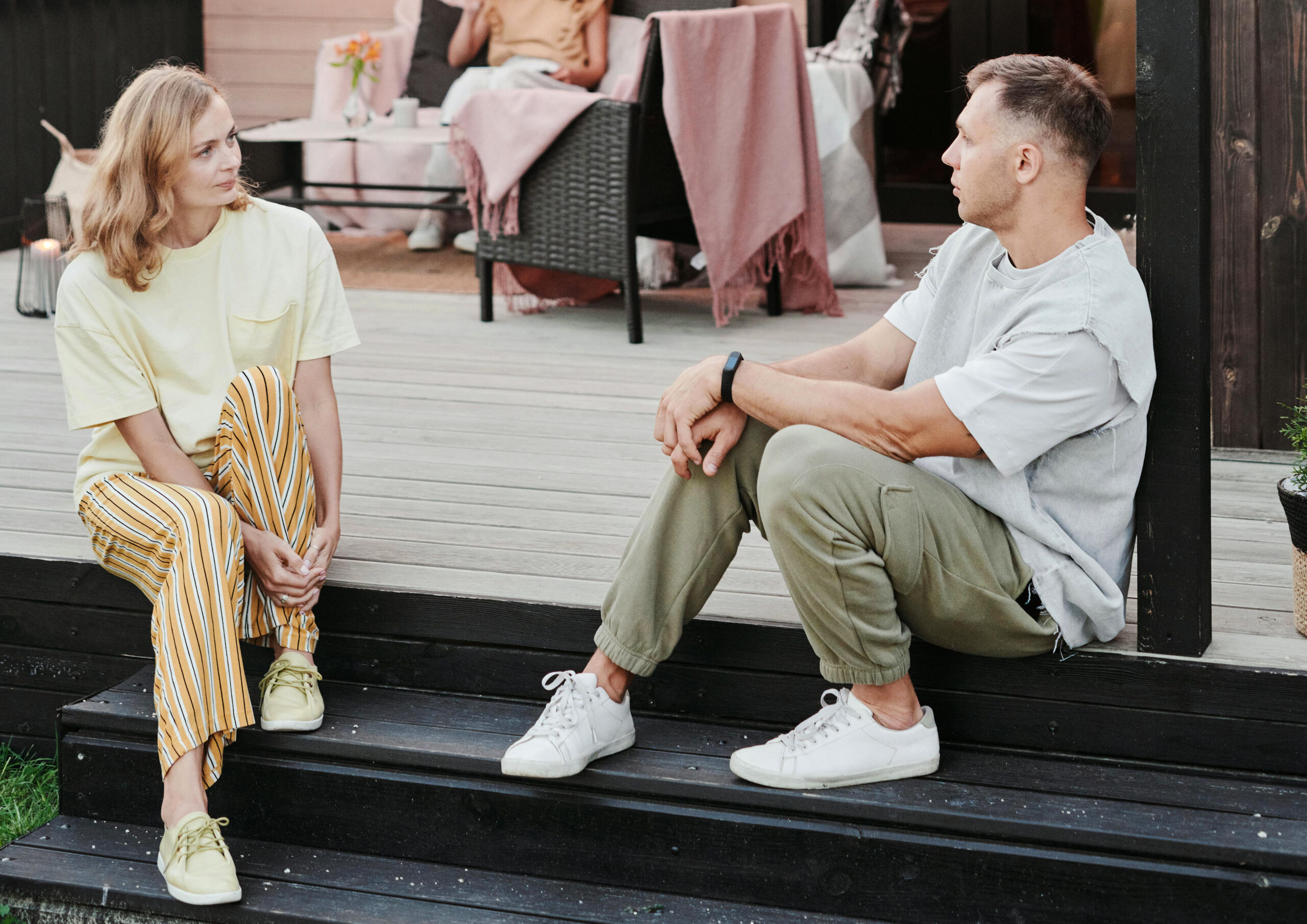 A woman and a man talking on a porch
