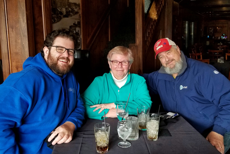 Thomas and his parents seated at a restaurant table
